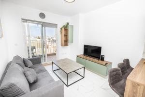 a living room with a couch and a tv at kensington in St. Paul's Bay