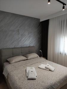 Un dormitorio con una cama con toallas. en Apartman Djuric 012, en Zlatibor