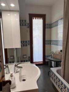 a bathroom with a sink and a tub and a mirror at My HOUSE in Roddino +7 photos