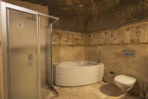 a bathroom with a bath tub and a toilet at Century Cave Hotel in Göreme +163 photos