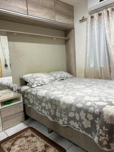 a bedroom with a large bed and a window at Apartamento em Condomínio ao lado do Shopping in Ananindeua