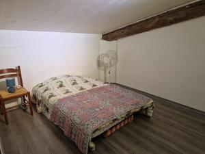 a bedroom with a bed and a fan and a chair at Loft in Aujeurres