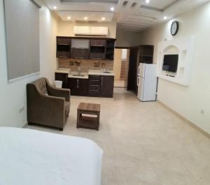 a kitchen with a couch and a table and a refrigerator at شقق مفروشه قارا in Qārā +32 photos