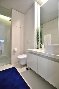 ein Badezimmer mit Toilette, Waschbecken und Spiegel in der Unterkunft RestOnDouro Oporto Family in Valbom