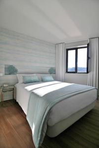 ein Schlafzimmer mit großem Bett und Fenster in der Unterkunft RestOnDouro Oporto Family in Valbom