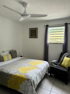 a bedroom with a bed and a ceiling fan at Chermakish Exceptional View Logement 3 Chambres, Piscine in Marigot