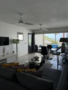 a living room with a couch and a table at Chermakish Exceptional View Logement 3 Chambres, Piscine in Marigot +23 photos