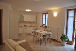 a living room with a couch and a table and chairs at Cadari' Appartamenti in Castel Condino