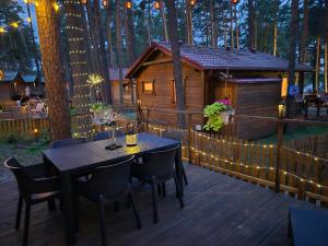 a wooden deck with a table and a cabin at Dzik w zagrodzie in Borsk