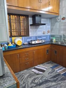 a kitchen with wooden cabinets and a counter top at Vasantham Villas in Puducherry