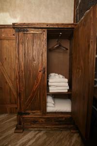 a wooden cabinet with white towels in a room at Gyumri Inn Guest House in Gyumri