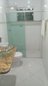 a bathroom with a toilet and a glass shower at Flat, Refúgio Beira Mar in Santa Cruz Cabrália