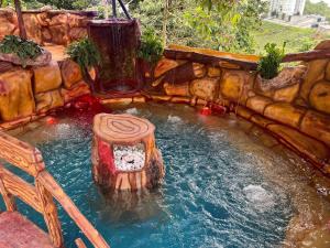 a small pool with a waterfall in a backyard at Hotel Golden Hills Manizales in Manizales