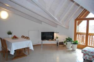 a living room with a table and a tv at Cadari' Appartamenti in Castel Condino