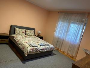 a bedroom with a bed and a large window at Prestige in Podgorica