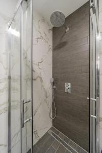 a bathroom with a shower with a glass door at Hemingway Belgrade Apartment in Zemun