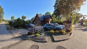 a house with a blue car parked in a driveway at Dom Derbend na wyłączność in Sztutowo
