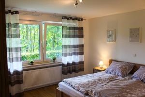 a bedroom with a bed and a window at Ferienwohnung Repetal in Attendorn +4 photos