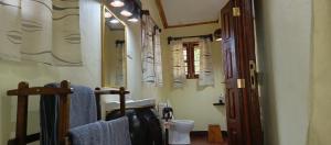 a bathroom with a sink and a toilet and a mirror at Kilimanjaro Lodge Cabins in Moshi