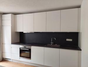 a kitchen with white cabinets and a sink at Saroja Plus in Brand