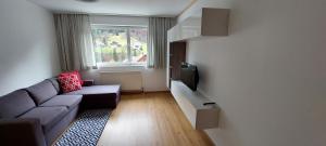 Elle comprend un petit salon doté d'un canapé et d'une télévision. dans l'établissement Saroja Plus, à Brand