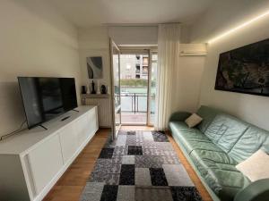 a living room with a couch and a flat screen tv at Appartamento spazioso in centro in Piacenza