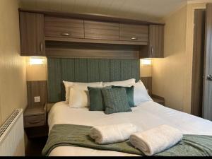 a bedroom with a large bed with two towels on it at Luxurious 2 Bedroom Caravan in Longniddry