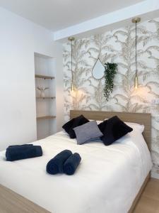 a bedroom with a white bed with blue pillows at L'ESCALE DOREE, Centre-ville et gare à pied in Vannes