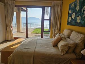 a bedroom with a bed with a view of the ocean at Pecanwood Home Away from Home in Hartbeespoort +37 photos