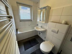 een witte badkamer met een toilet en een wastafel bij Naturfreude Bad Harzburg in Bad Harzburg +16 foto's