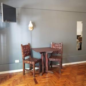 een tafel en twee stoelen en een televisie in een kamer bij Bonpland Studio in Buenos Aires