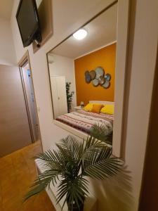 lustro w sypialni z łóżkiem i rośliną w obiekcie Terrazza vicino al mare w Rimini
