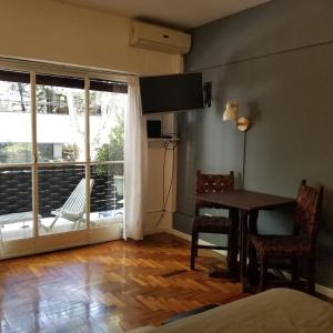 een woonkamer met een tafel en een glazen schuifdeur bij Bonpland Studio in Buenos Aires