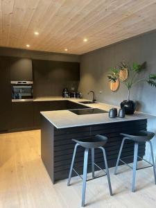 Una cocina con dos taburetes de bar y un fregadero. en Hovden Alpin Lodge! Ski in out, en Hovden