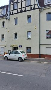 a white car parked in front of a building at Cherry Apartments- CHILL in Wałbrzych