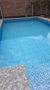 einen großen blauen Pool mit Ziegelwand in der Unterkunft Casa Reyes in Reyes