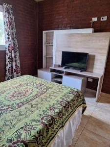 ein Schlafzimmer mit einem Bett und einem Schreibtisch mit einem Laptop in der Unterkunft Casa Reyes in Reyes + 8 Fotos