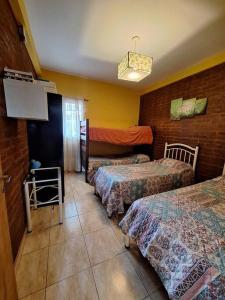 ein Hotelzimmer mit zwei Betten und einem Fernseher in der Unterkunft Casa Reyes in Reyes