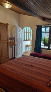 a bedroom with a large bed and two windows at Alojamiento peregrinos al pie del camino in Vigo