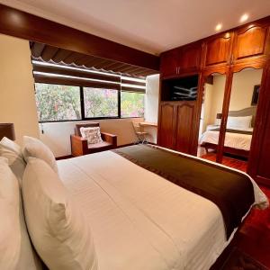 Un dormitorio con una gran cama blanca y una ventana. en Casa Lloret, en Cuenca