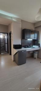 a kitchen with black cabinets and a white counter top at olivegrove in Sidari