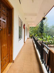a corridor of a house with a wooden door at Dubare plantation stay in Siddapur