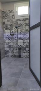 a room with a bathroom with a tile wall at olivegrove in Sidari