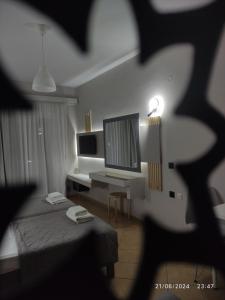 a room with a bed and a desk with a monitor at olivegrove in Sidari