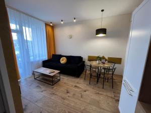 een woonkamer met een bank en een tafel bij Apartament BELMARE F522 in Międzyzdroje +6 foto's