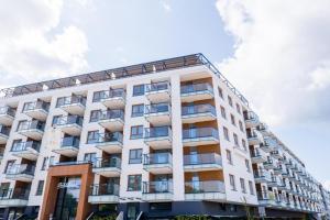 een hoog wit gebouw met balkons erop bij Apartament BELMARE F522 in Międzyzdroje