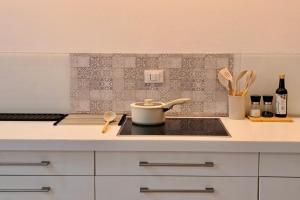a kitchen with a stove with a pot on it at Cozy Casa Bianca Bergamo in Alzano Lombardo +8 photos