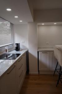 a kitchen with white cabinets and a counter top at La Perla Apartment in Taranto