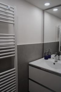 a bathroom with a sink and a mirror at La Perla Apartment in Taranto +5 photos
