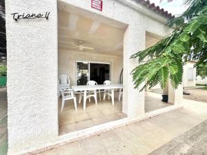 a white table and chairs on a patio at Triana II, Primera línea de mar, La Azhoía in Cartagena